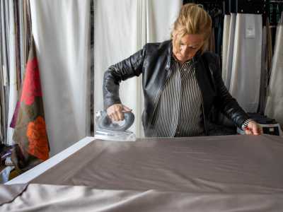 ...e stira il drappo in seta di una tenda...